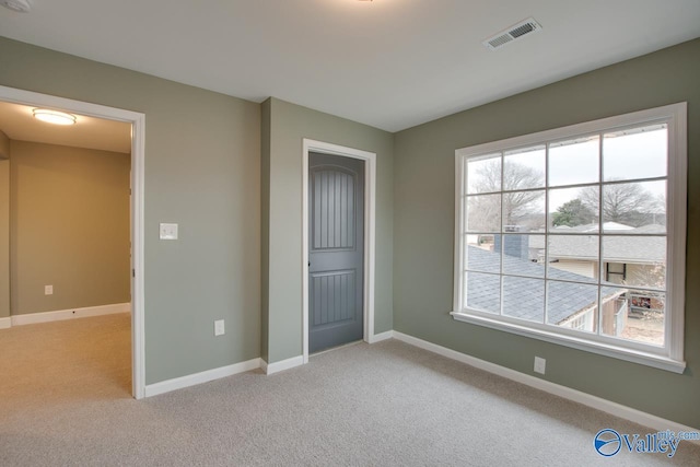 unfurnished bedroom with light colored carpet and a closet