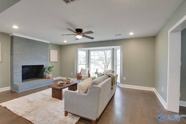 living room with a fireplace, dark hardwood / wood-style floors, and ceiling fan