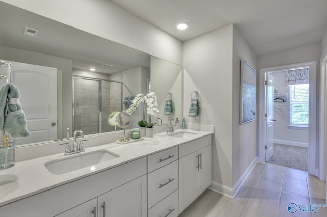 bathroom with double vanity, a sink, visible vents, and tile patterned floors