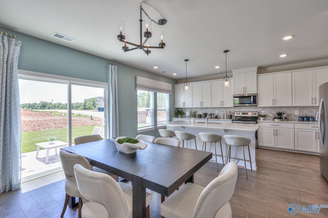 dining room featuring light wood-style floors, visible vents, a chandelier, and recessed lighting