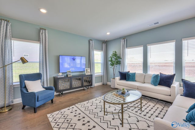 living area featuring baseboards, wood finished floors, and recessed lighting