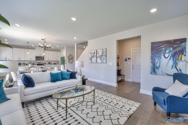 living room featuring a notable chandelier, baseboards, wood finished floors, and recessed lighting