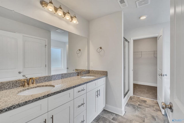 bathroom with a sink, visible vents, and a stall shower