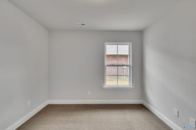 carpeted spare room with visible vents and baseboards