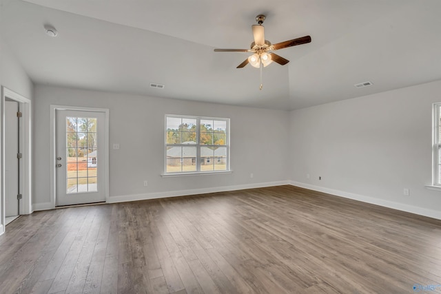 spare room featuring dark wood finished floors, baseboards, visible vents, and ceiling fan