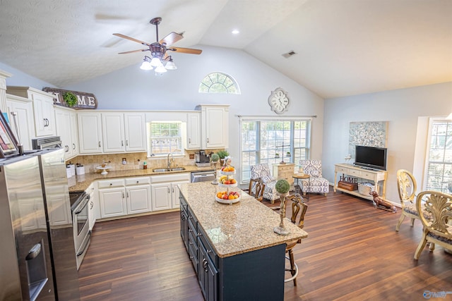 kitchen with dark wood-type flooring, sink, white cabinetry, a kitchen island, and ceiling fan