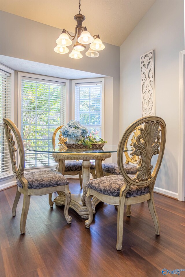 dining space with an inviting chandelier, lofted ceiling, and dark wood-type flooring