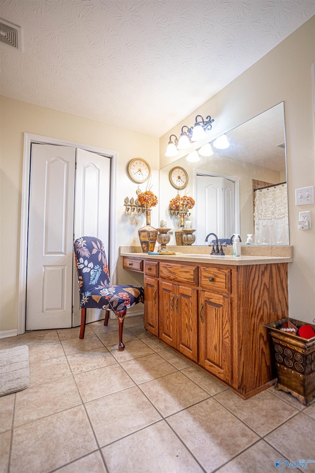 bathroom featuring a textured ceiling, vanity, and tile patterned floors