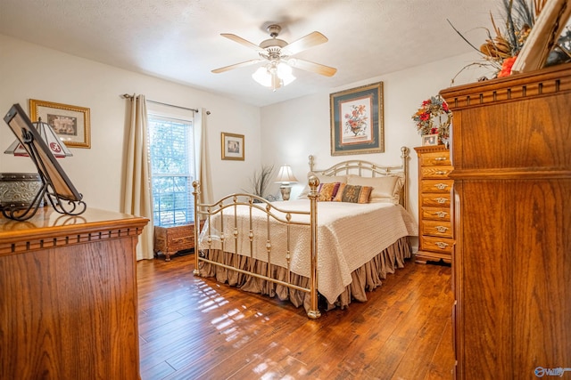 bedroom featuring ceiling fan, dark wood-type flooring, and a textured ceiling