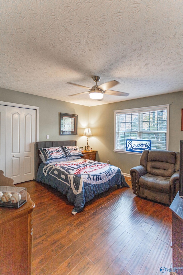 bedroom featuring ceiling fan, a textured ceiling, a closet, and dark hardwood / wood-style flooring