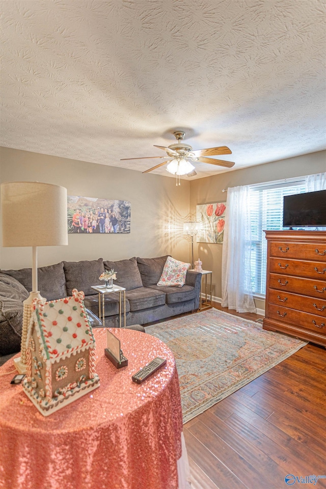 living room featuring a textured ceiling, hardwood / wood-style floors, and ceiling fan