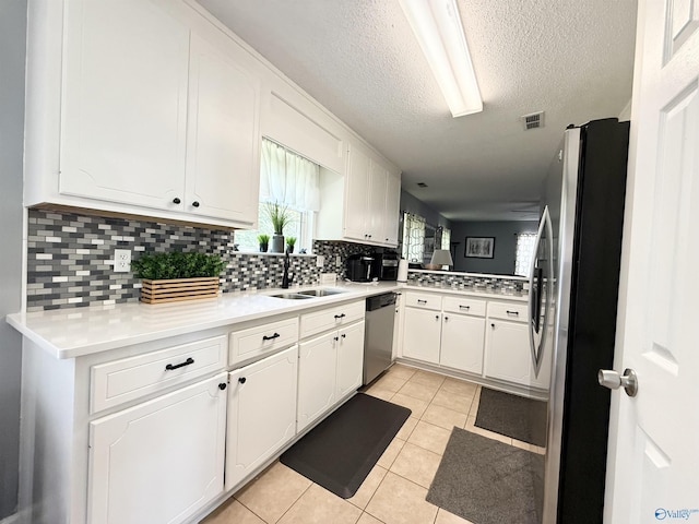 101 Maple Valley Dr, Madison, AL 35758 - kitchen featuring appliances with stainless steel finishes, white cabinets, a textured ceiling, and backsplash