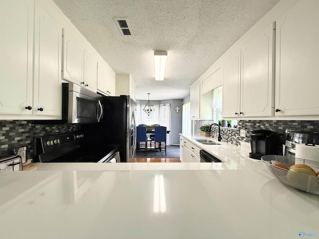 101 Maple Valley Dr, Madison, AL 35758 - kitchen featuring appliances with stainless steel finishes, a textured ceiling, white cabinetry, light countertops, and backsplash