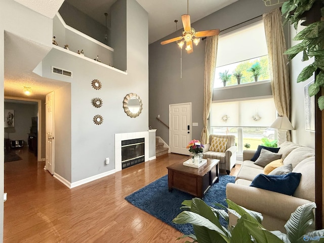 101 Maple Valley Dr, Madison, AL 35758 - living area featuring a high ceiling, wood finished floors, a ceiling fan, healthy amount of natural light, and stairway