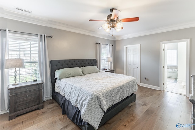 bedroom featuring crown molding, hardwood / wood-style floors, and multiple windows