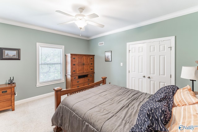 carpeted bedroom featuring ceiling fan, ornamental molding, and a closet