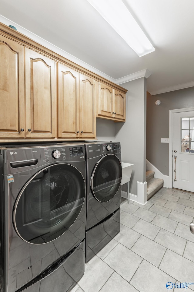 clothes washing area with cabinets, crown molding, separate washer and dryer, and light tile patterned floors