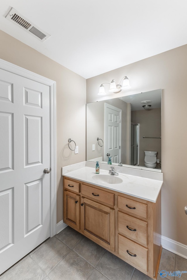 bathroom with vanity, tile patterned floors, and toilet