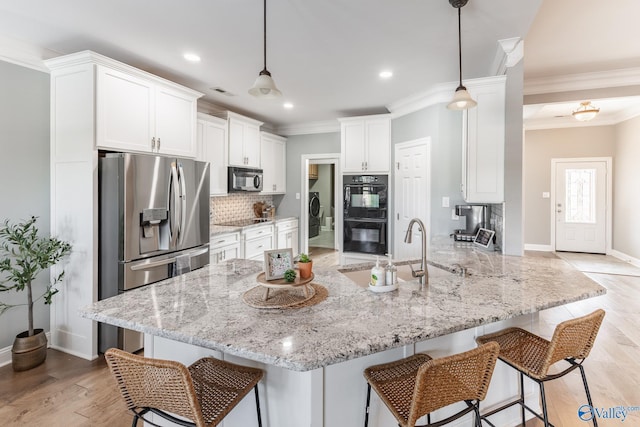 kitchen featuring white cabinetry, hanging light fixtures, black appliances, and kitchen peninsula