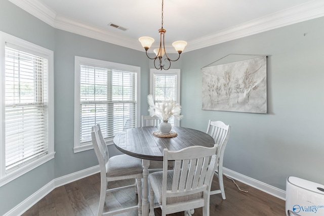 dining room featuring dark wood-type flooring, ornamental molding, and a chandelier