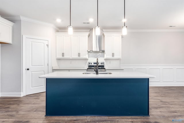 kitchen featuring a kitchen island with sink, hanging light fixtures, and wall chimney exhaust hood