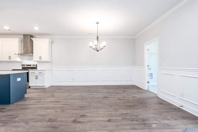 kitchen featuring a notable chandelier, white cabinetry, wall chimney range hood, and stainless steel range with electric cooktop