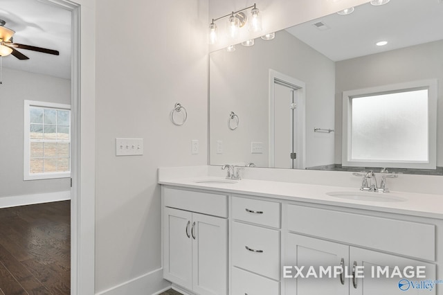 full bath featuring double vanity, wood finished floors, a sink, and visible vents