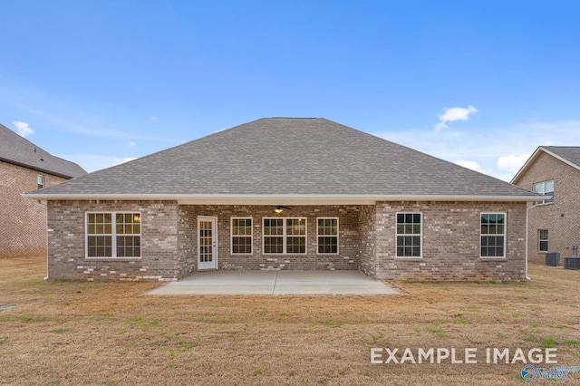 back of property featuring a yard, brick siding, a patio, and roof with shingles