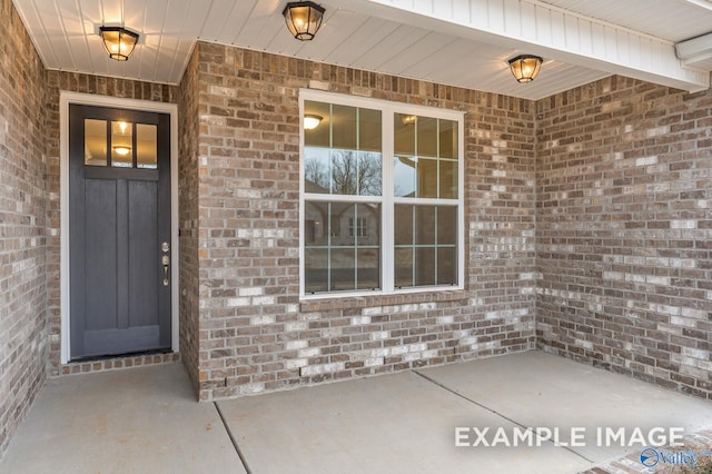 doorway to property with brick siding