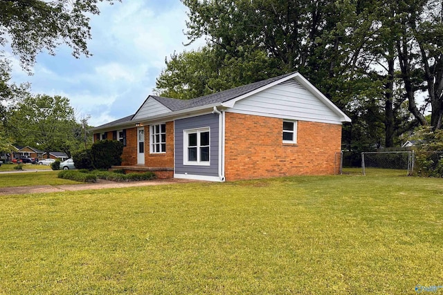 1701 Golf Club Ln NW, Huntsville, AL 35816 - view of property exterior featuring a lawn, fence, and brick siding