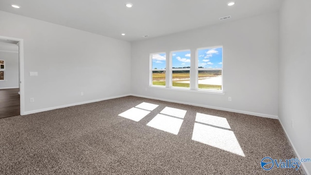 spare room with dark carpet