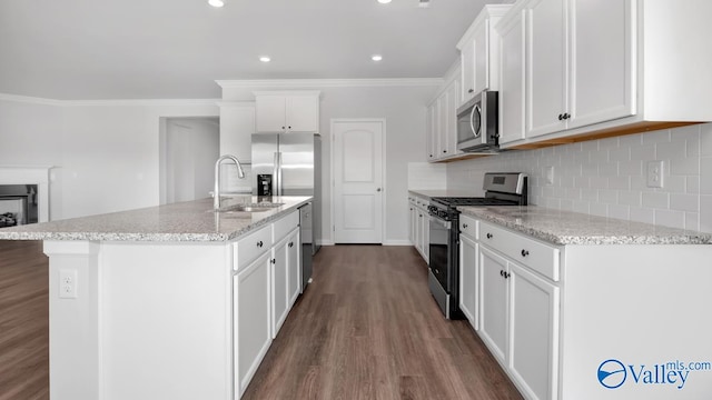 kitchen featuring a kitchen island with sink, hardwood / wood-style flooring, stainless steel appliances, sink, and white cabinets