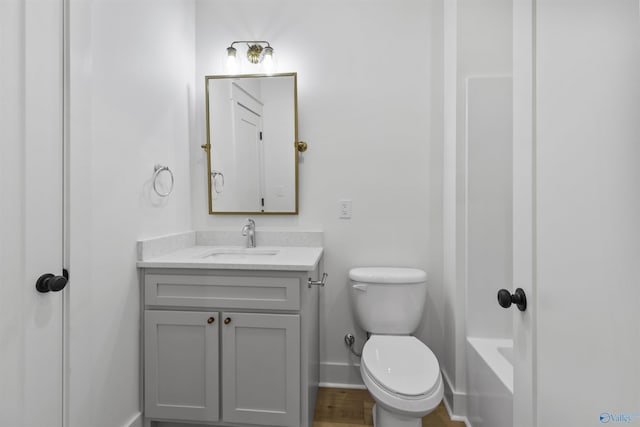 full bathroom with a washtub, baseboards, toilet, and vanity