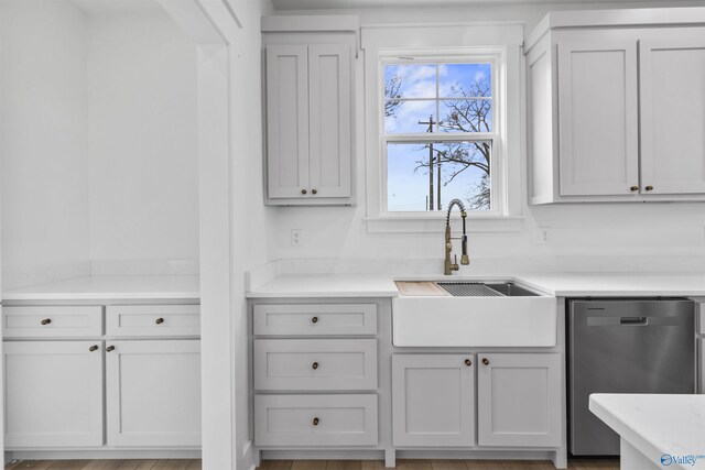 kitchen with a sink, light countertops, and dishwasher