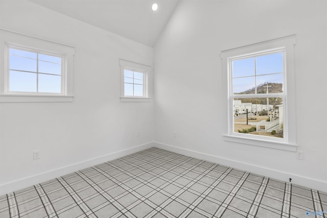 spare room featuring baseboards, lofted ceiling, and recessed lighting