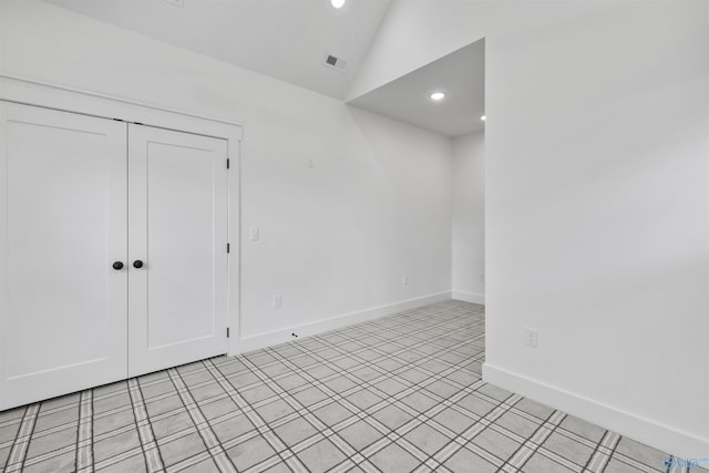 empty room featuring visible vents, baseboards, vaulted ceiling, and recessed lighting