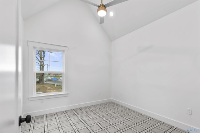 empty room featuring baseboards and high vaulted ceiling