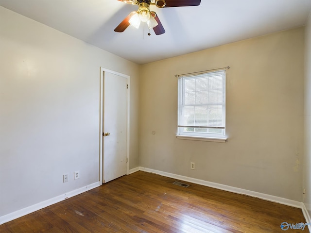 empty room with ceiling fan and dark hardwood / wood-style flooring