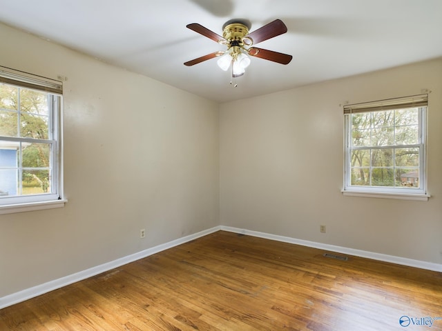 empty room with ceiling fan and hardwood / wood-style flooring