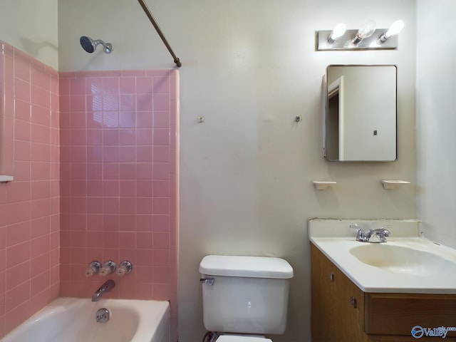 full bathroom featuring tiled shower / bath combo, toilet, and vanity