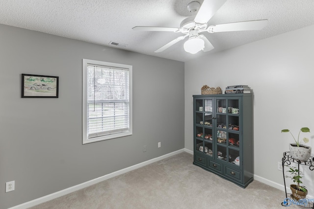 miscellaneous room with ceiling fan, light carpet, and a textured ceiling