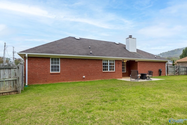 rear view of house with a patio area and a yard