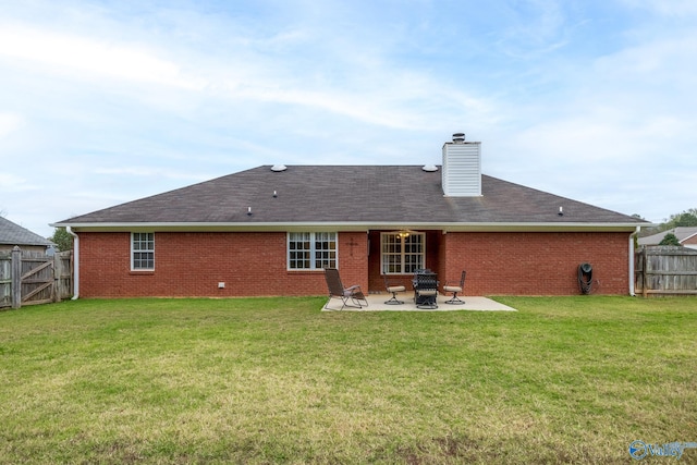 rear view of property featuring a lawn and a patio area