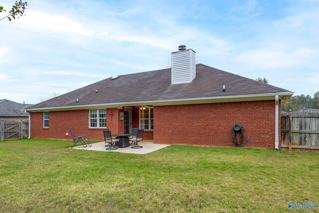 rear view of property featuring a yard and a patio