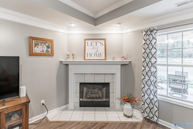 living room featuring crown molding, a fireplace, and light hardwood / wood-style flooring