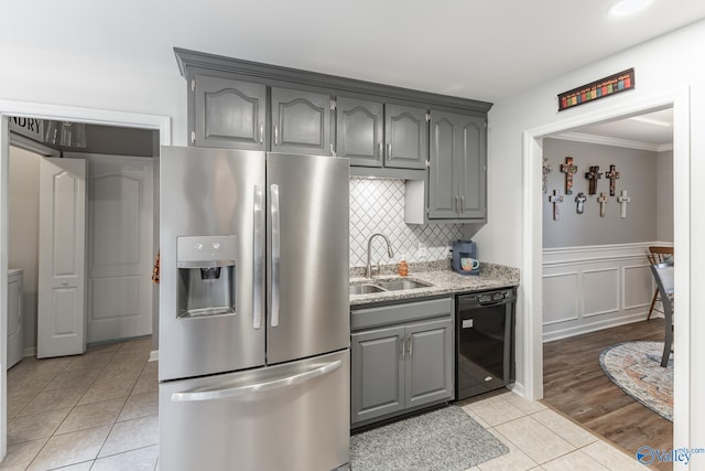 kitchen featuring gray cabinetry, sink, stainless steel fridge, black dishwasher, and light tile patterned flooring