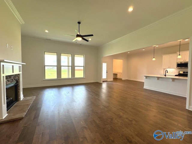 unfurnished living room with crown molding, dark hardwood / wood-style floors, a premium fireplace, and ceiling fan