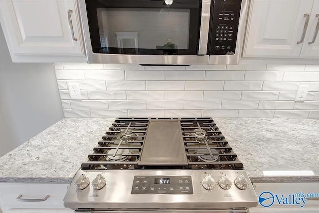 17401 Stonegate Dr, Athens, AL 35613 - kitchen view of appliances with stainless steel finishes, white cabinetry, decorative backsplash, and light stone countertops