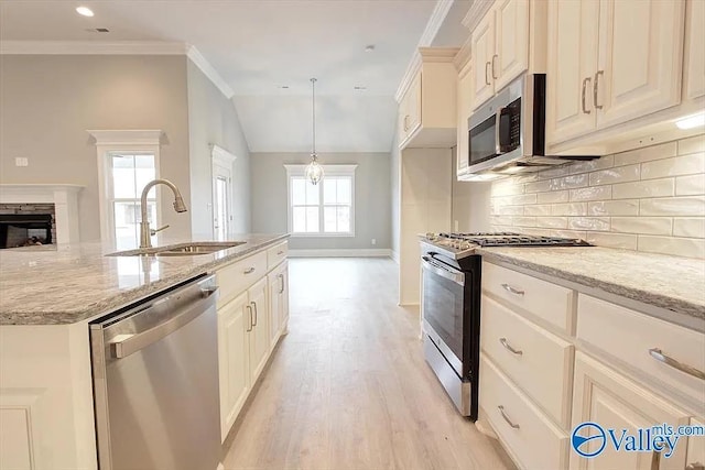 17401 Stonegate Dr, Athens, AL 35613 - kitchen with stainless steel appliances, a sink, decorative backsplash, light wood finished floors, and light stone counters