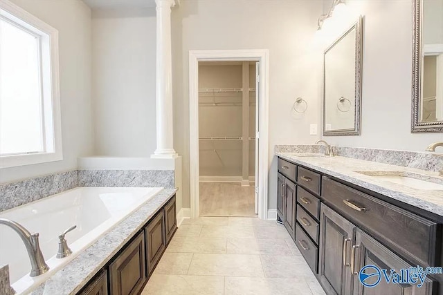 17401 Stonegate Dr, Athens, AL 35613 - full bathroom with ornate columns, a walk in closet, a bath, double vanity, and tile patterned floors